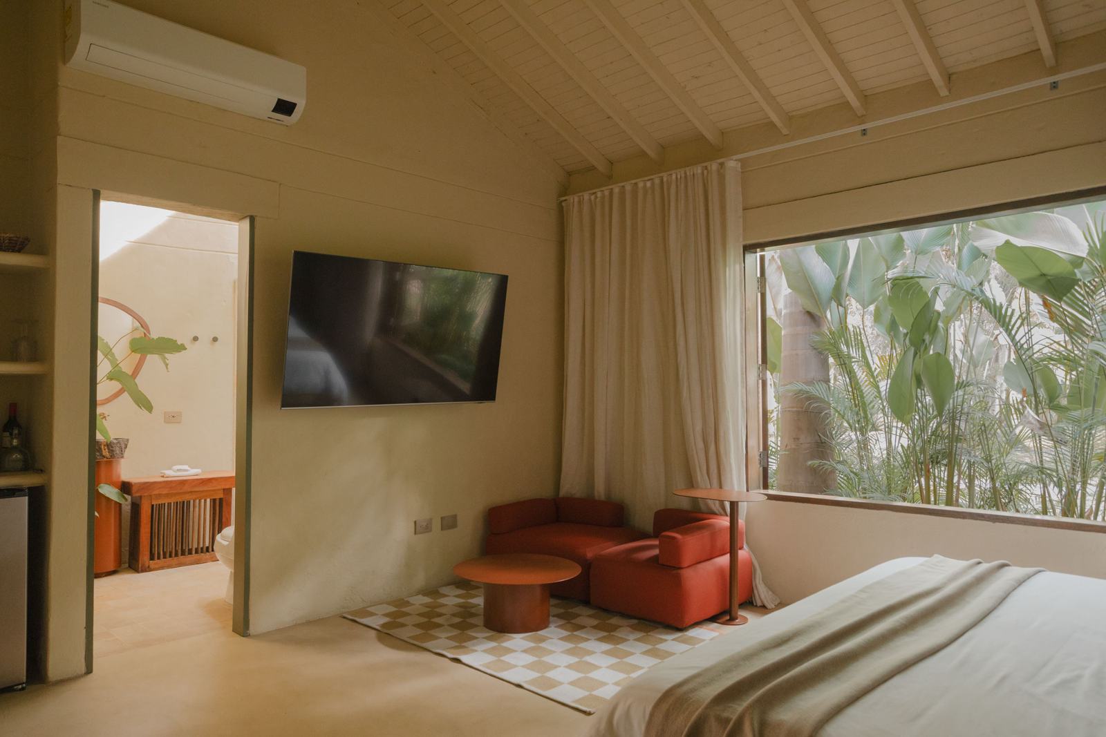 Interior de suite con luz de atardecer, techos altos y detalles curados